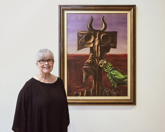 Barbara Jools with the painting she and her late husband Dr Nic Jools have gifted to the Art Gallery of NSW, Albert Tucker's *The Intruder* (1964)